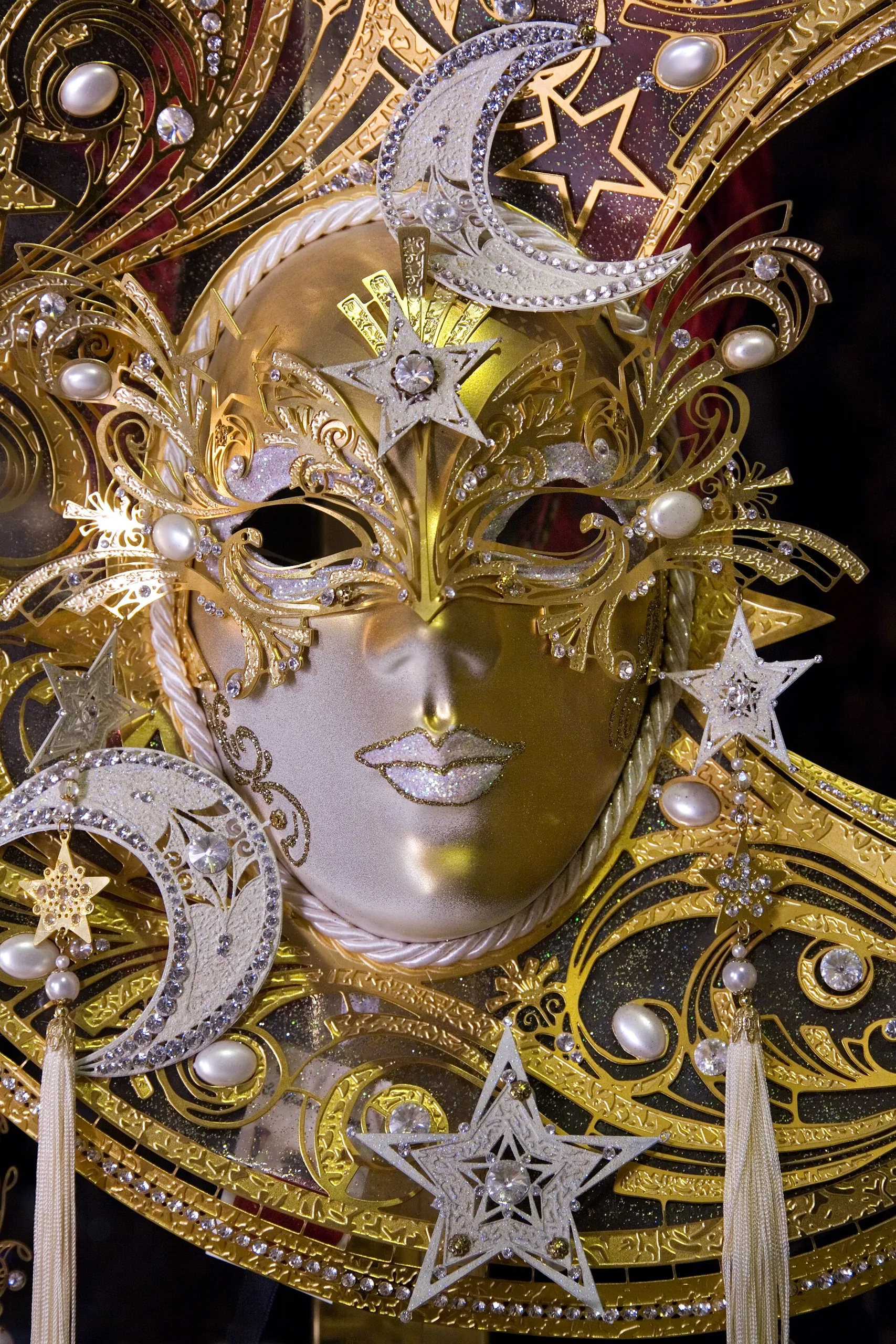 Maschera veneziana elaborata con decorazioni dorate a tema stelle e lune, tipica del Carnevale di Venezia